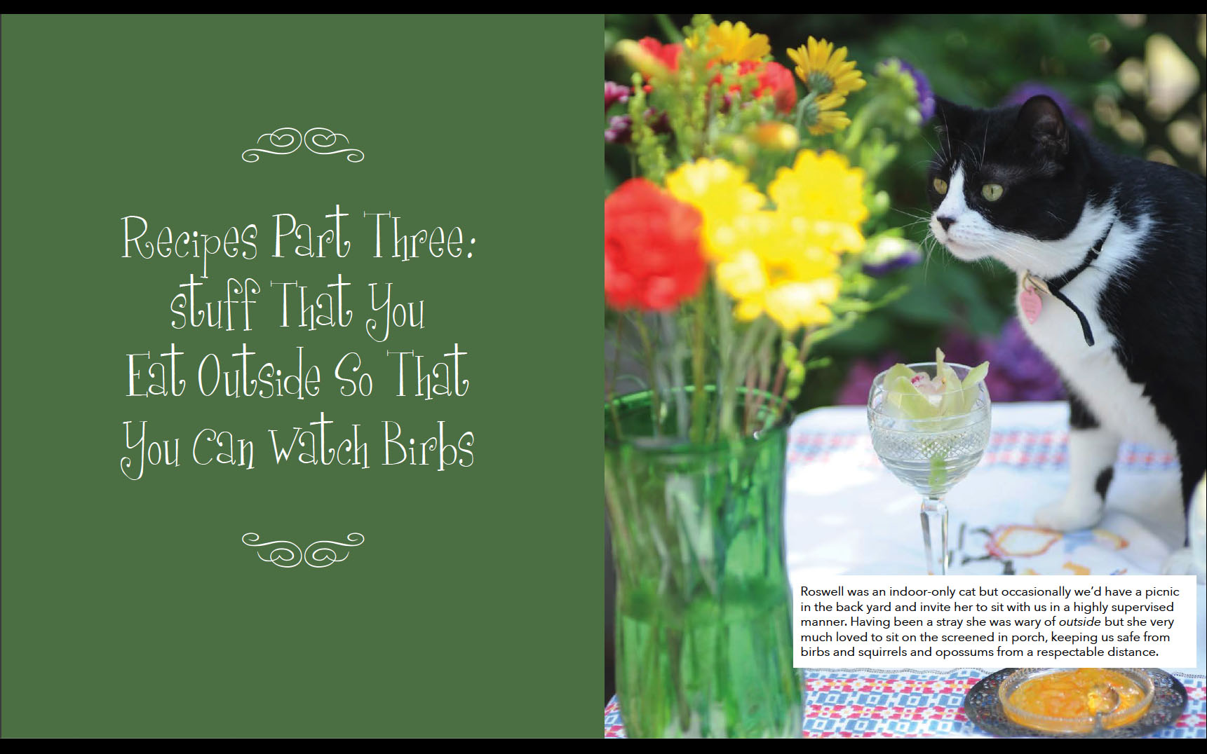 Photograph of a
        tuxedo cat sitting at a table sniffing flowers
